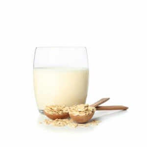 Oat milk and oatmeels in spoon isolated on white background